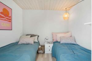 1 dormitorio con 2 camas y mesita de noche en Summerhouse Just A Stones Throw From The Waters Edge, en Karrebæksminde