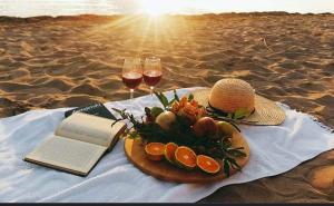 a table with a plate of fruit and wine glasses on the beach at Studio apartman Endy in Ploče