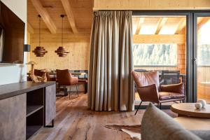 salon z drewnianymi ścianami i dużym oknem w obiekcie Alm-Lodges Montafon by Pferd auf Wolke w mieście Gargellen