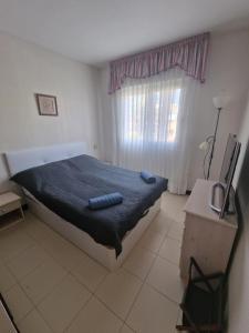 Un dormitorio con una cama con dos toallas azules encima. en First line sea apartments, en Torrevieja 25 fotos más