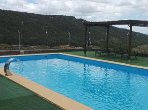 una gran piscina azul con cenador en Casas Rurales Ivan El Penas en Benizar
