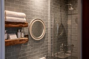 a bathroom with a shower and a mirror and towels at The Crown Inn Pooley Bridge in Pooley Bridge