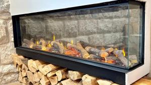 a fireplace filled with logs in a room at Boutique apartment in heart of Haifa in Haifa