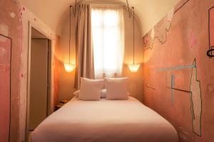 Postel nebo postele na pokoji v ubytování Hôtel La Prison