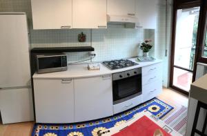 uma cozinha branca com um fogão e um micro-ondas em B&B Pontepiccolo em Catanzaro