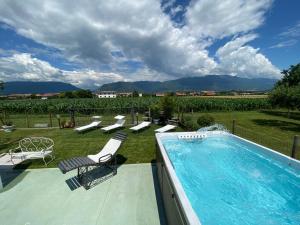 basen z leżakami i krzesłami obok dziedzińca w obiekcie Romantica camere Le Fate con Vista sulle Montagne vicino a Bassano del Grappa w mieście Romano D'Ezzelino