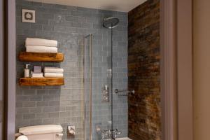 een badkamer met een glazen douche, een toilet en handdoeken bij The Crown Inn Pooley Bridge in Pooley Bridge