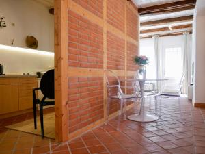 リューネブルクにあるStay Hygge - Zentrales Altstadt-Apartment in Lüneburg mit kostenfreiem Parkplatzのレンガの壁、テーブルと椅子が備わる客室です。