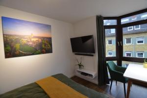 a bedroom with a bed and a flat screen tv at Studio 7 City Lage mit Garage nähe Köln Bonn in Siegburg