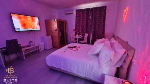 a purple bedroom with a bed and a tv at Mé Besito in Ari