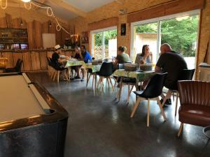 un gruppo di persone seduti ai tavoli in un ristorante di Camping Ardennes Insolites a Marbehan