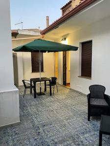 d'une terrasse avec une table et un parasol vert. dans l'établissement Casa Elena, à Gonnesa