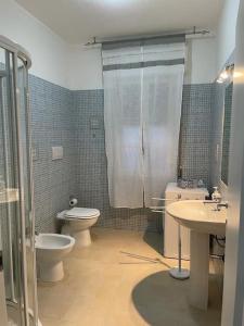 La salle de bains est pourvue de toilettes, d'un lavabo et d'une douche. dans l'établissement Casa Elena, à Gonnesa