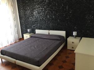 - une chambre avec un lit et un mur noir dans l'établissement Casa Elena, à Gonnesa