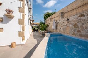 a swimming pool in a house with a stone wall at Pool Villa Michail, in Kissamos! in Koukounará