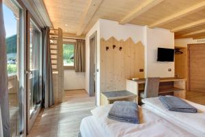 um quarto com 2 camas e uma secretária com um computador em Agriturismo Bosco d'oro 4 em Livigno