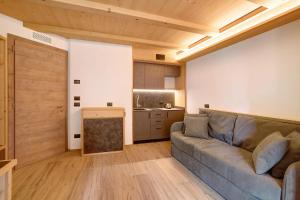 a living room with a couch and a kitchen at Agriturismo Bosco d'oro 4 in Livigno