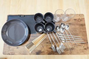 a table with a plate and utensils and wine glasses at Setagaya House by Tranova in Tokyo