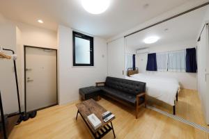 1 dormitorio con sofá, cama y mesa en Setagaya House, en Tokio