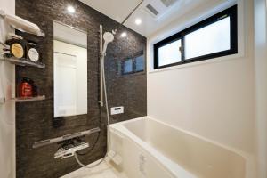 a bathroom with a tub and a sink and a mirror at Setagaya House by Tranova in Tokyo +20 photos