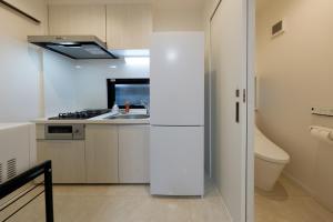 a kitchen with a white refrigerator and a sink at Setagaya House in Tokyo