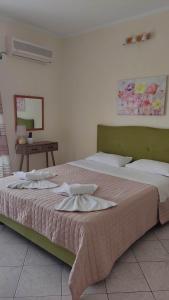 a bedroom with two beds and a table with a mirror at EVIA DREAM FAMILY APARTMENTS in Edipsos