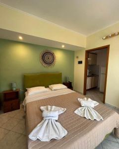 een slaapkamer met een groot bed en 2 witte handdoeken bij EVIA DREAM FAMILY APARTMENTS in Edipsos