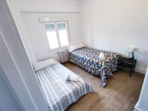 Cette petite chambre comprend 2 lits et une fenêtre. dans l'établissement Mariña Home, à Ourense