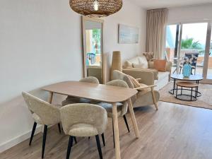 een woonkamer met een houten tafel en stoelen bij Malibu mancion 2 dormitorios in Mijas Costa
