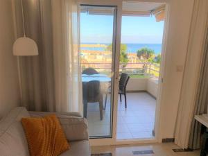 een woonkamer met een bank en een balkon met een tafel bij Acogedor apartamento frente al mar con piscina in Altea