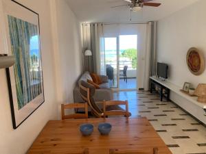 ein Wohnzimmer mit einem Sofa und einem Tisch in der Unterkunft Acogedor apartamento frente al mar con piscina in Altea