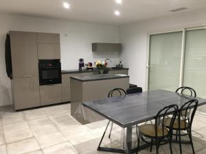 a kitchen with a table and chairs in a room at Maison familiale avec piscine à 3km de la plage in Latour-Bas-Elne