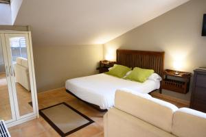 1 dormitorio con cama con almohadas verdes y sofá en Hotel Spa Gametxo, en Ibarrangelu