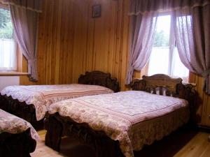 - une chambre avec 2 lits dans une pièce avec fenêtres dans l'établissement База відпочинку Гаївка котедж, à Klevanʼ