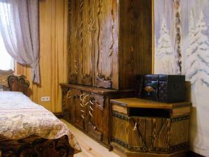 a bedroom with a large wooden cabinet next to a bed at База відпочинку Гаївка котедж in Klevanʼ