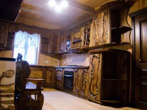 a kitchen filled with wooden cabinets and a window at База відпочинку Гаївка котедж in Klevanʼ