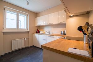 een keuken met witte kasten en een aanrecht bij Viktoria B33, Wohnung mit herrlicher Aussicht in Arosa