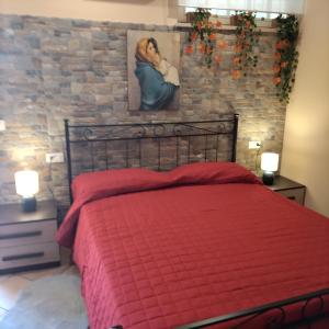 una camera con letto rosso e parete in pietra di B&B VILLA RITA a Silvi Marina