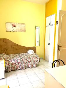 1 dormitorio con 1 cama y paredes amarillas en OSTELLO MADRE SANTINA, en Lecce