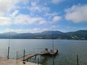 a dock on a lake with mountains in the background at Casa Alle in Eşelniţa