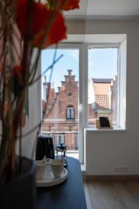 une table avec deux tasses et un vase avec des fleurs dans l'établissement Odit, à Bruges