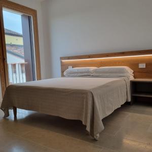 Cama en habitación con ventana grande en Corte Bottura agriturismo, en Castelnuovo del Garda