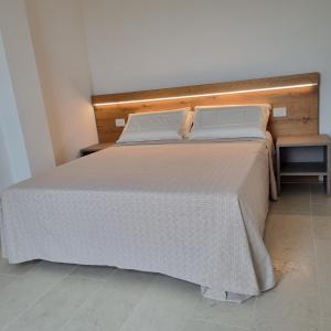 1 dormitorio con 1 cama grande con colcha blanca en Corte Bottura agriturismo, en Castelnuovo del Garda