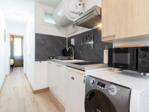 a kitchen with a washer and dryer in it at La Petite Parenthèse Vienna Authentica in Vienne