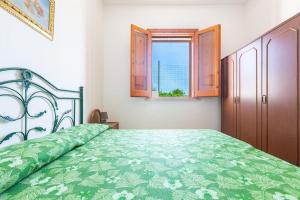 una camera con letto verde e finestra di Salentoandmore - Anna Rita Guest House a Marina di Leuca
