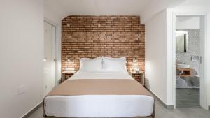 a bedroom with a large bed and a brick wall at Armenakishouses in Pollonia