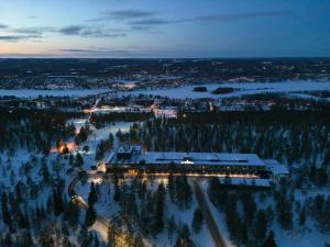 an aerial view of a resort in the snow at night at Lapland Hotels Sky Ounasvaara in Rovaniemi