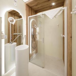 La salle de bains est pourvue d'une douche avec une porte en verre. dans l'établissement Przylądek Marzeń - Domy nad morzem, à Ustronie Morskie