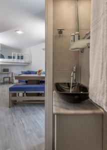 a bathroom with a sink and a living room at Armenakishouses in Pollonia