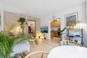 een woonkamer met planten en een bakstenen muur bij Great central apartment walking distance to metro in Kopenhagen